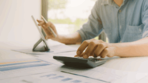 Illinois resident calculating alimony payments at home with financial documents and calculator showing payment difficulties